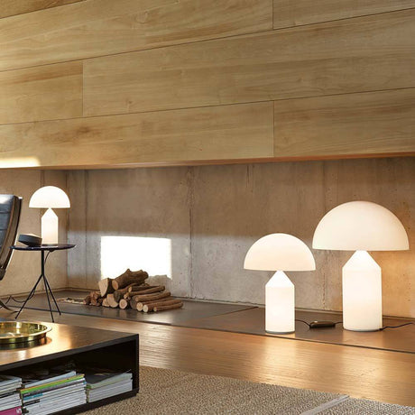 Oluce Glas Tischleuchte Atollo 35 Opal in modernem Wohnraum mit natürlichem Holz und minimalistischer Einrichtung.