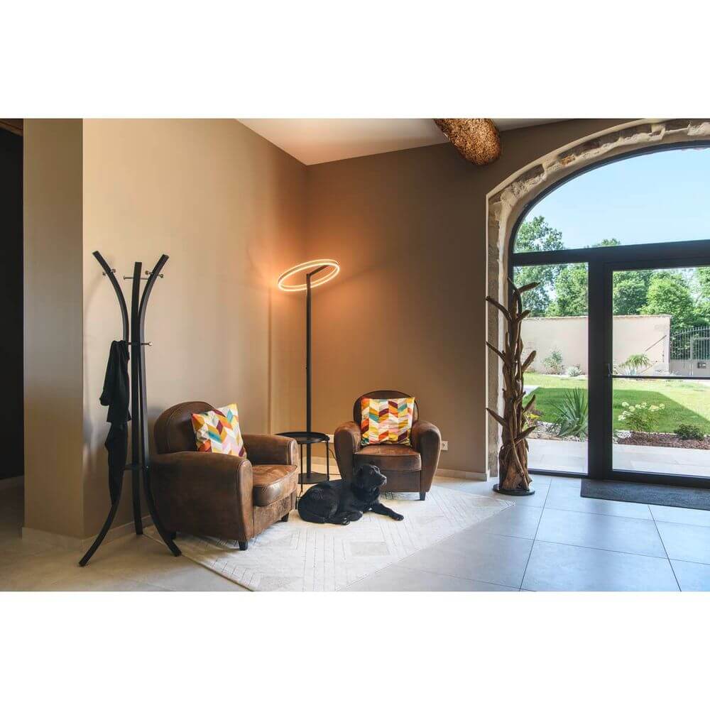 Elegante One Straight FL Stehleuchte in einem stilvollen Wohnraum mit gemütlichen Sesseln und einem Hund.