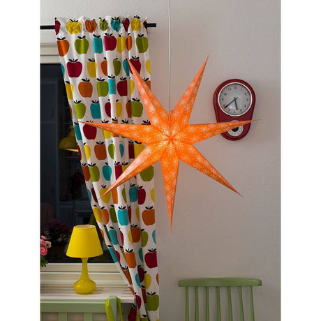 Oranger Papierstern perforiert mit weiß bedrucktem Muster 7 Zacken ohne Leuchmittel in gemütlicher Raumdeko.
