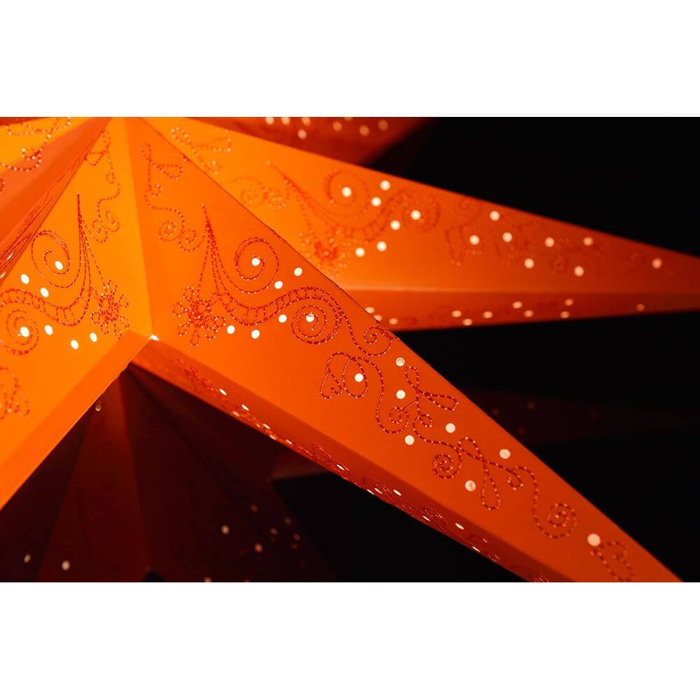 Oranger Papierstern perforiert orange bestickt 7 Zacken ohne Leuchtmittel in stimmungsvoller Detailansicht.