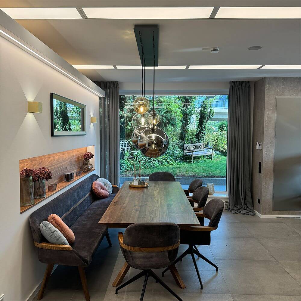 s.luce Orb Esszimmerlampe 12-flammig 160cm 2-reihig über einem eleganten Esstisch in modernem Ambiente.