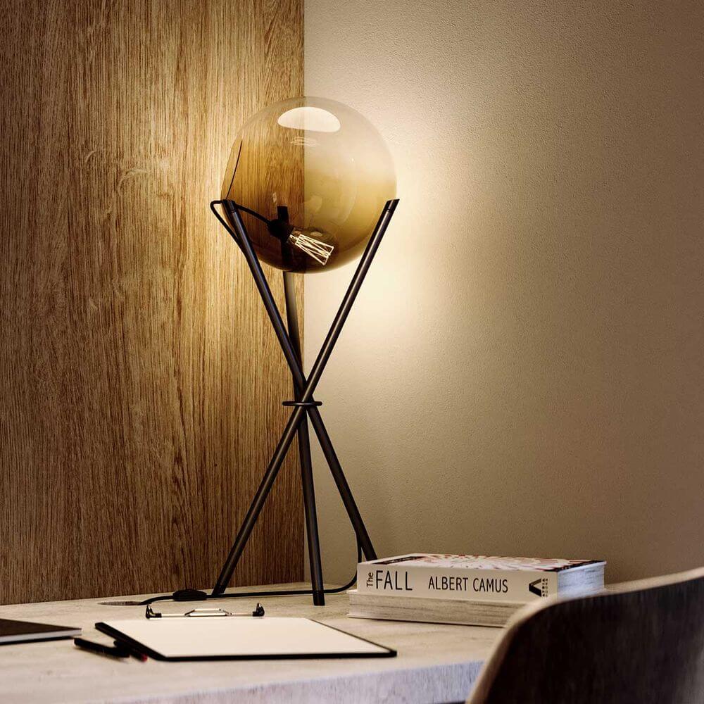 s.luce Orb Axis Glas-Tischlampe Dreibein 20cm auf einem Tisch mit modernem Design und sanftem Licht.