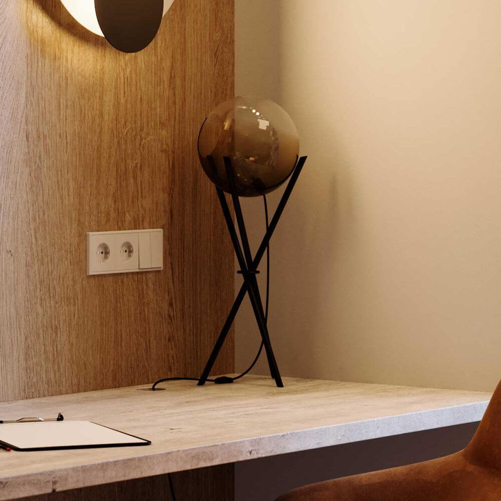 s.luce Orb Axis Glas-Tischlampe Dreibein 20cm auf einem modernen Tisch mit Holzverkleidung.