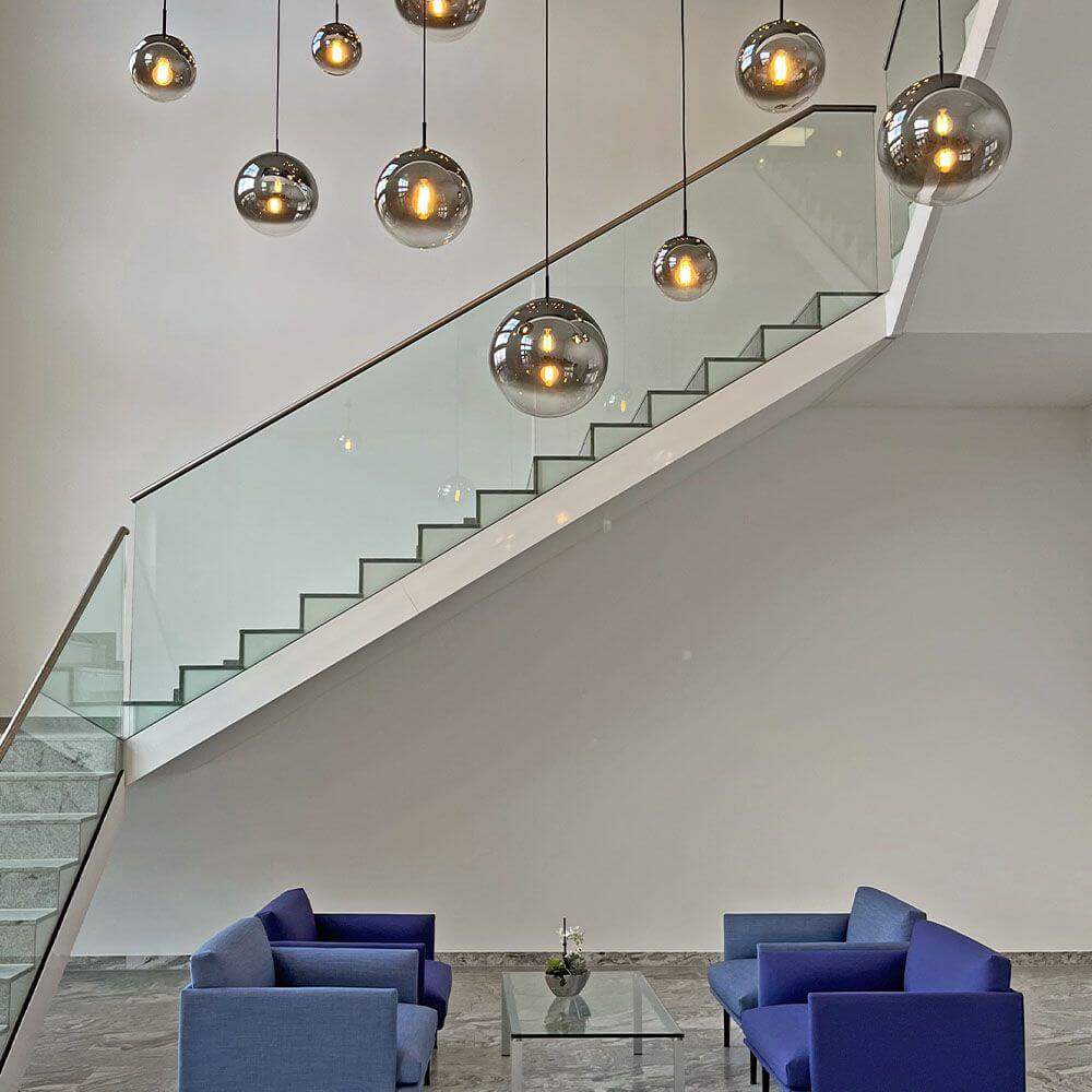 s.luce Orb Glaskugel Galerieleuchte 500cm Aufhängung Schwarz über modernem Treppenhaus.