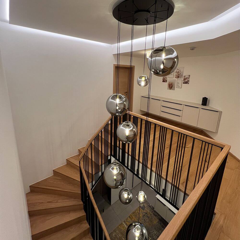 s.luce Orb Glas-Pendelleuchte in Schwarz, moderne Hängelampe über Treppe, stilvoll und elegant.