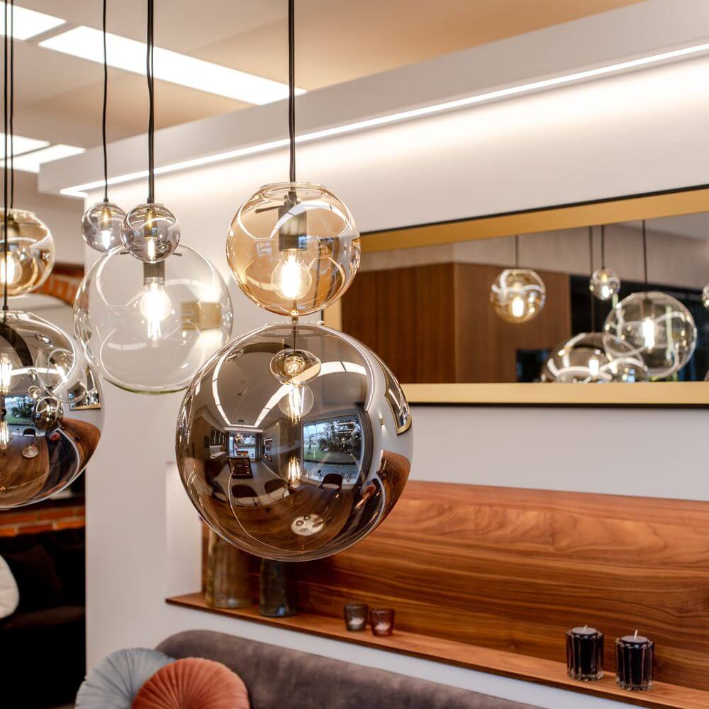 s.luce Orb Hängelampe in modernem Interieur, elegante Glas-Kugelleuchten über einem Sofa.