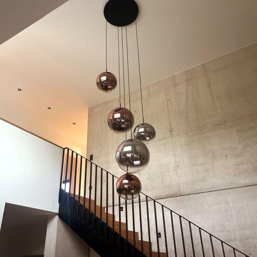 s.luce Orb Glaskugel Hängeleuchte elegant über Treppe aufgehängt mit mehreren gläsernen Kugeln.