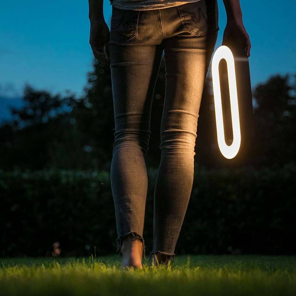 LED Akkuleuchte Moval IP44 370lm 3000K USB in Benutzung im Garten bei Nacht, warmweißes Licht scheit heraus.