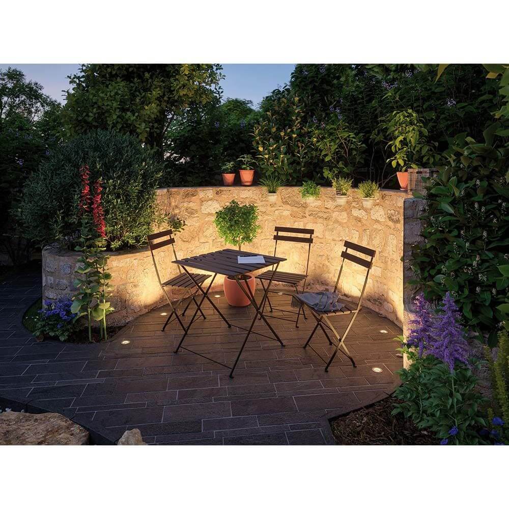 LED Plug & Shine Floor Mini Erweiterungsset IP65 24V 3000K 3x2, 5W beleuchtet einen gemütlichen Gartenbereich.