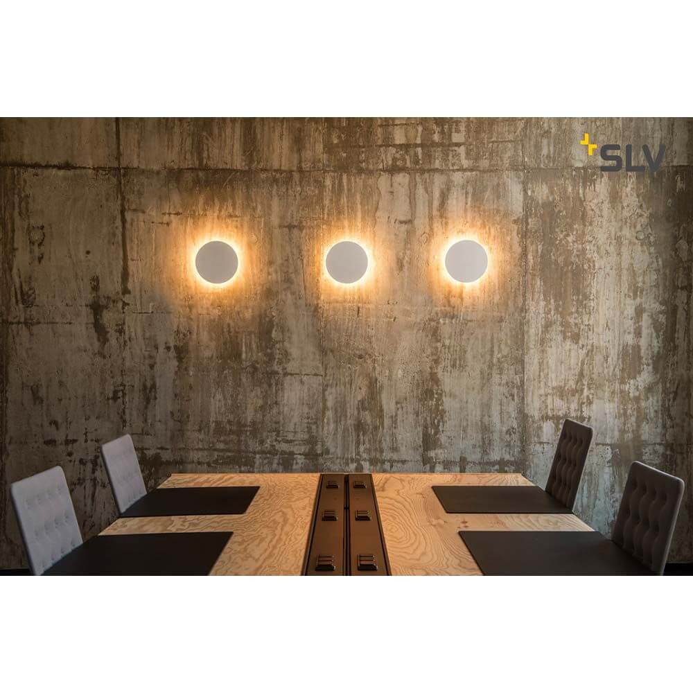 Plastra Gips Wandleuchte LED 3000K Rund Ø33cm an einer Betonwand über einem Tisch