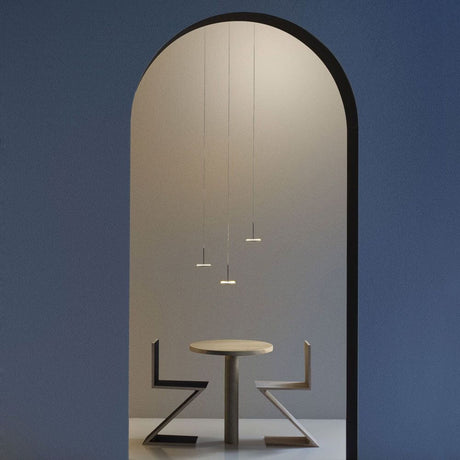 Panzeri Bella LED-Pendelleuchte direkt oder indirekt über einem modernen Tisch im stilvollen Interieur.
