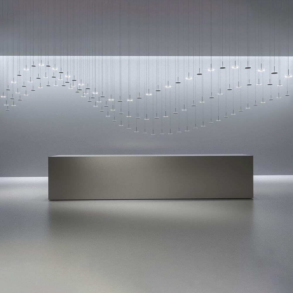 Moderne Innenarchitektur mit schwebenden Pendelleuchten über einem minimalistischen Tisch in neutralen Tönen.