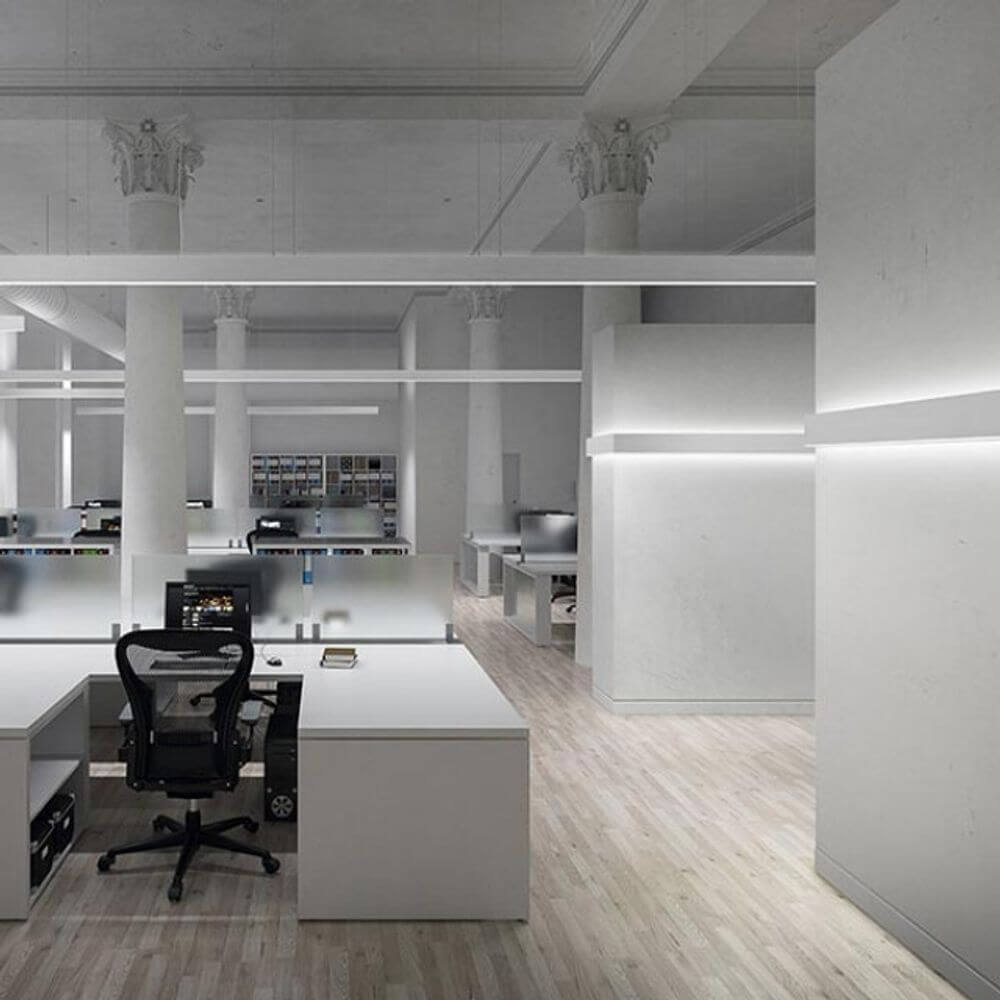Moderne Büroumgebung mit Panzeri Giano LED-Pendelleuchte indirekt/direkt UGR <19 über den Arbeitsplätzen.