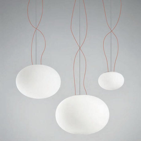 Panzeri Gilbert Glas Pendelleuchte in modernem Design, mit drei hängenden, weißen Glaskugeln und roten Kabeln.