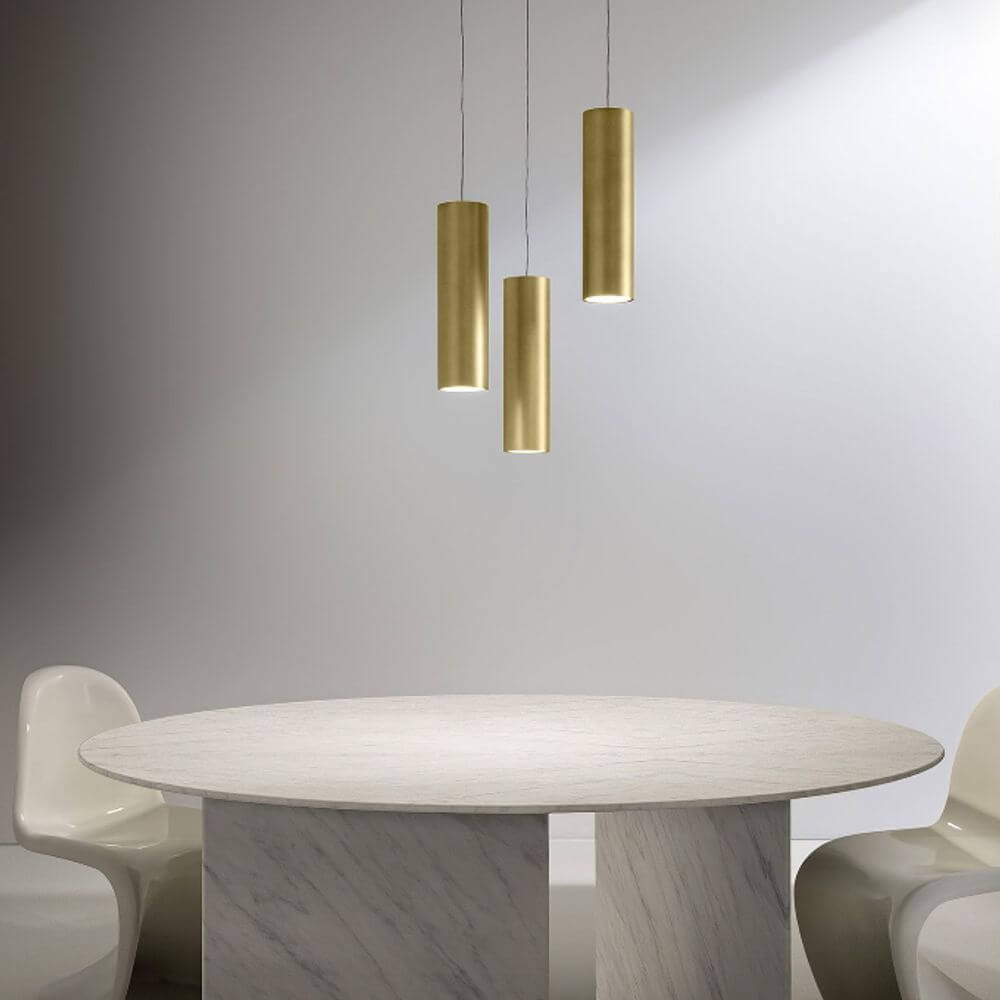 Panzeri One LED-Pendelleuchte aus Aluminium in satiniertem Messing über einem eleganten Tisch.