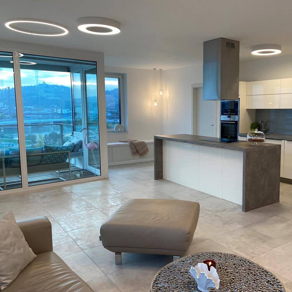 Moderne Wohnung mit Panzeri Silver Ring LED-Deckenlampe Dimmbar über der Küche und stilvoller Einrichtung.