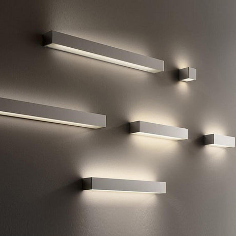Panzeri Toy lampa ścienna LED Up&Down 45 cm zamontowana na ścianie na różnych wysokościach.