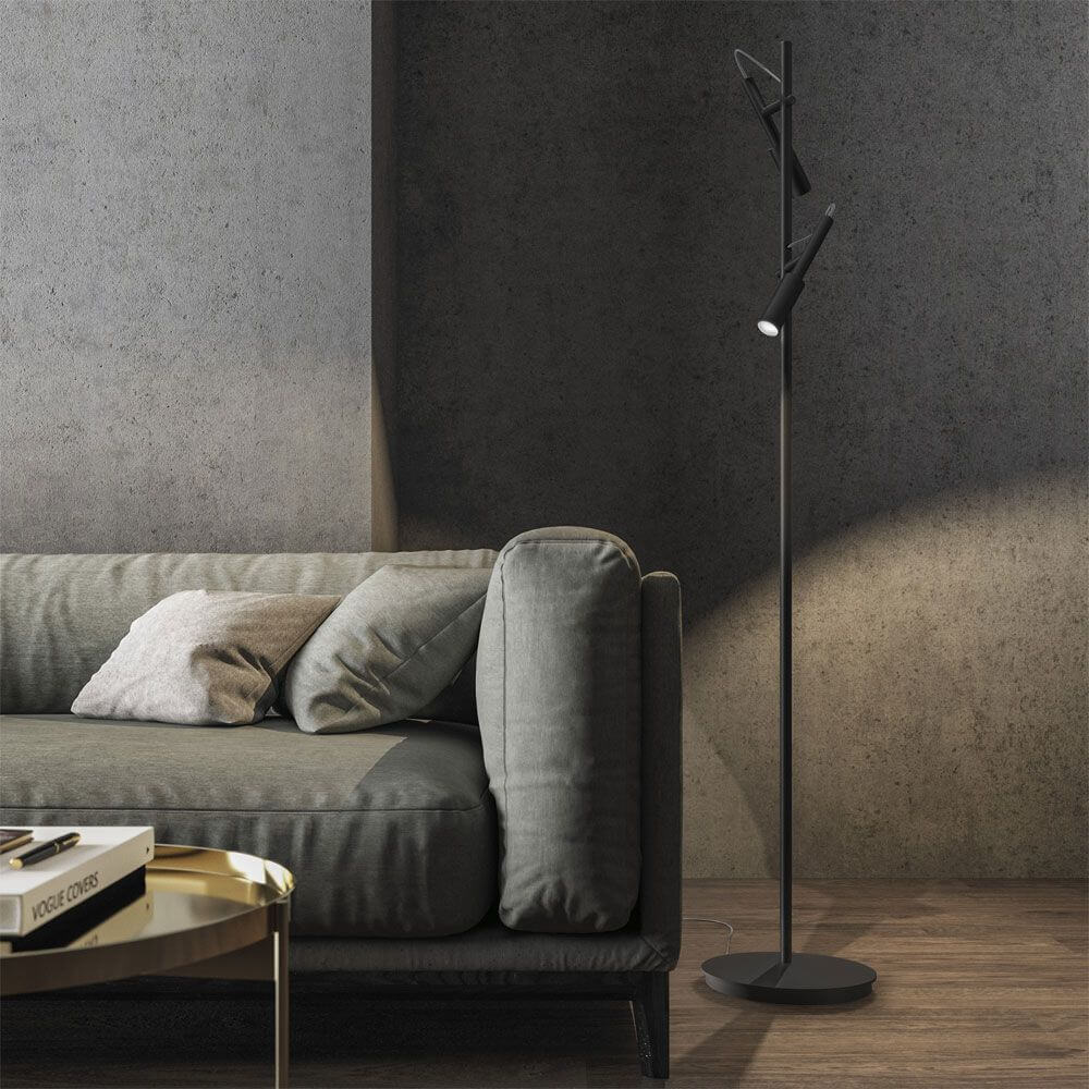 Panzeri Tubino LED Stehleuchte mit Doppelkopf neben einem Sofa in einem modernen Wohnraum.