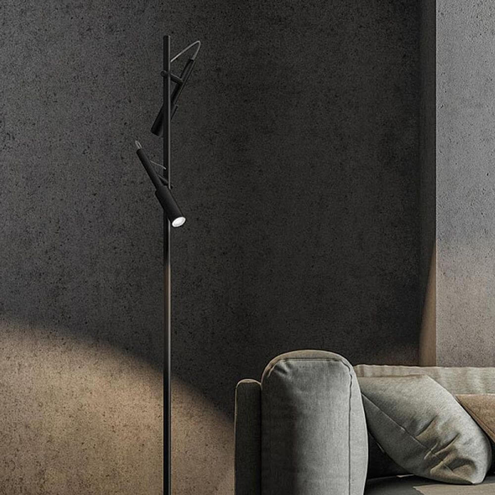 Panzeri Tubino LED Stehleuchte mit Doppelkopf in schwarzem Design neben einem Sofa.