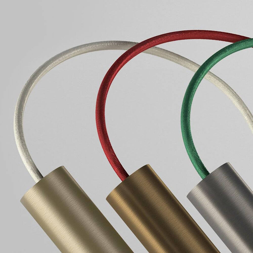 Nahaufnahme von bunten Textilkabeln in Rot, Grün und Weiß an der Panzeri Tubino Tischlampe.