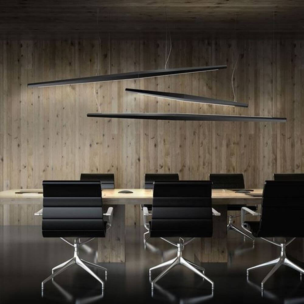 Panzeri Viisi Hängeleuchte aus Aluminium in modernem Konferenzraum mit schwarzen Stühlen.