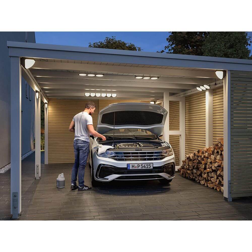 Mann arbeitet an einem Auto unter beleuchtetem Carport mit Park + Light Kabel 1m IP67 Schwarz.