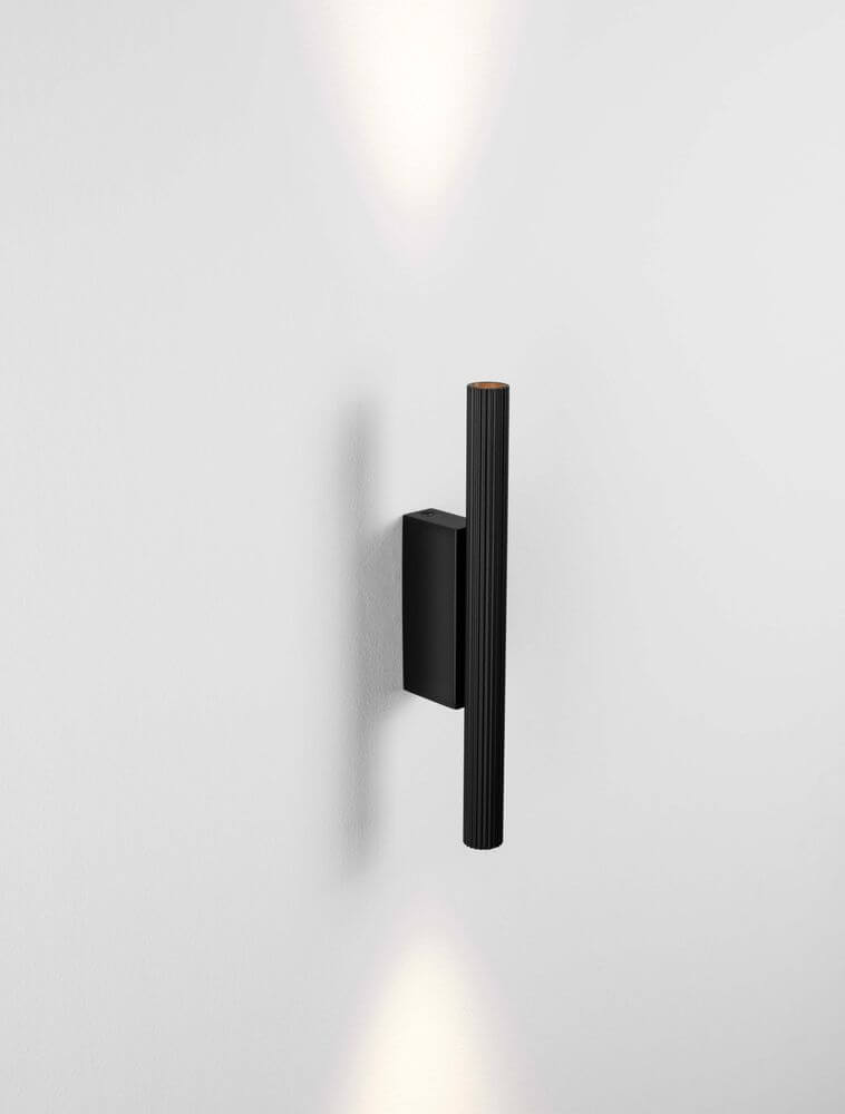 Paron LED Wandleuchte Geriffelt 3000K mit mattschwarzer Basis und goldfarbenem Korpus, indirektes Licht.