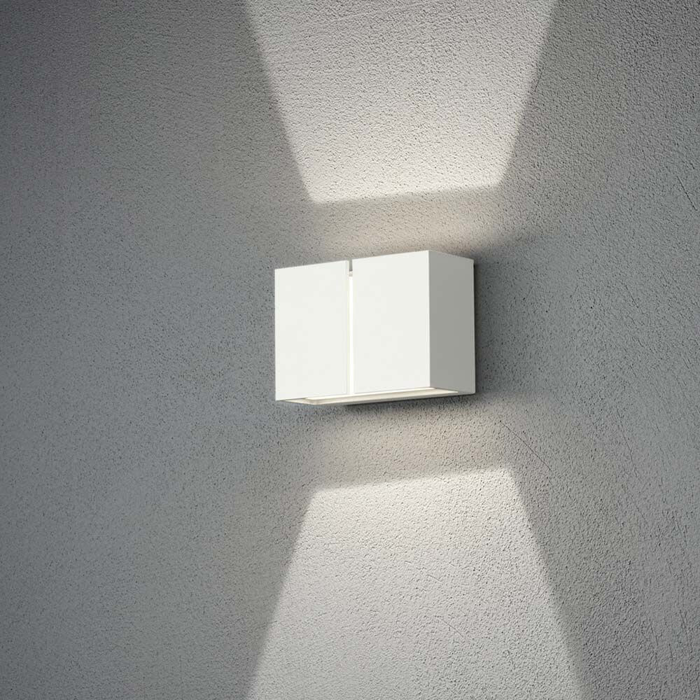 Pavia LED Außenwandleuchte in Weiß an einer Wand installiert, mit sanftem Lichtschein.
