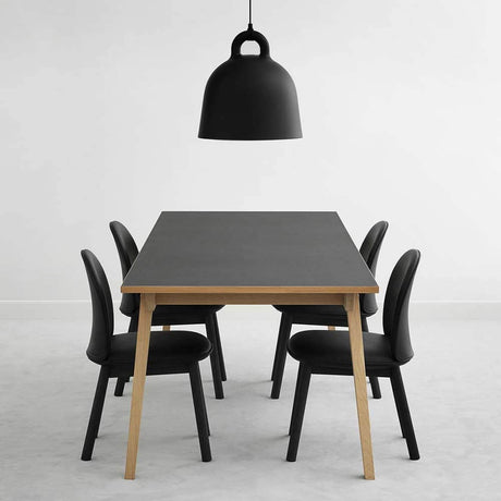 Lampa wisząca Bell L Ø 55cm czarna nad nowoczesnym stołem jadalnym z czarnymi krzesłami.