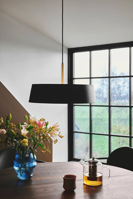 Clasi 45 pendant light in a modern room with flowers and tea on the table.