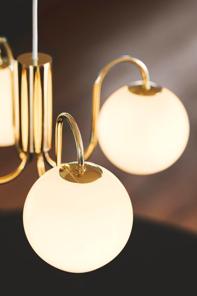 Pendelleuchte Franca mit glänzendem Messing und weißen Glaskuppeln für sanftes Licht.