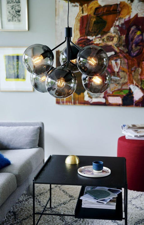 Pendelleuchte Ivona 6-Spot in modernem Wohnzimmer mit schwarzem Stahl und Rauchglas.
