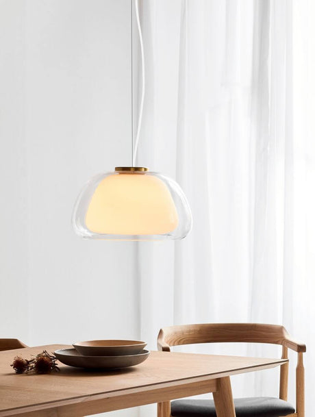 Jelly pendant light in a modern design, illuminating a dining area with warm light and elegant glass.