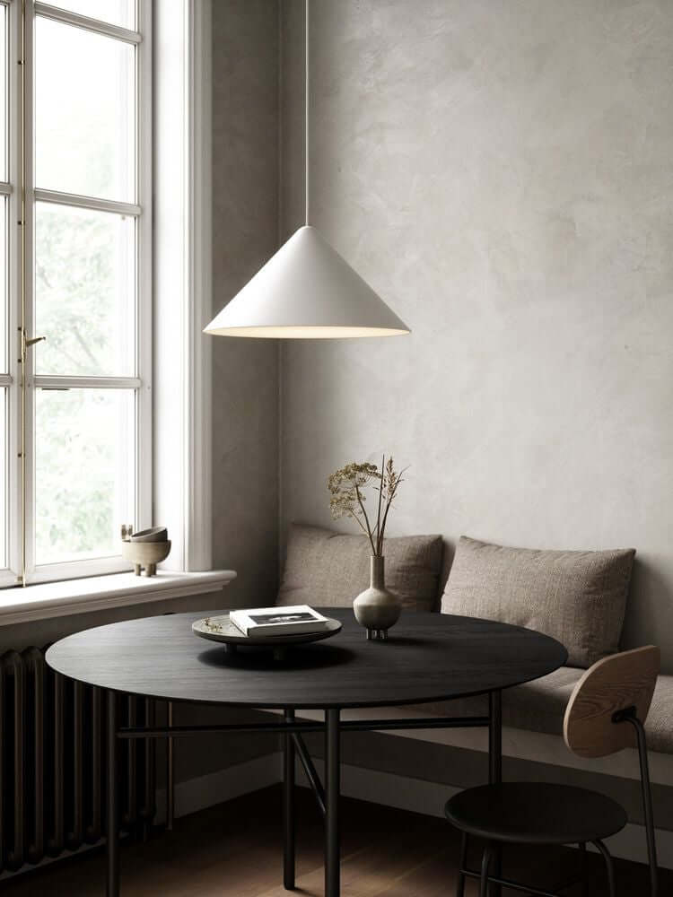Pendelleuchte Nono 49 über einem runden Tisch in einem modernen, minimalistisch eingerichteten Raum.