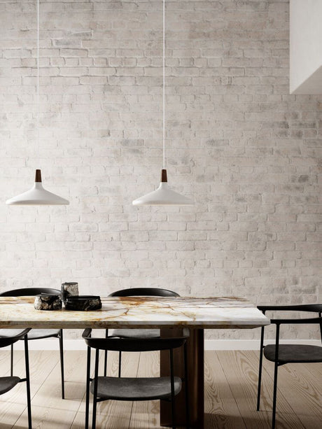 Pendelleuchte Nori 39 über einem minimalistischen Esstisch mit hellen Wänden und eleganten Stühlen.