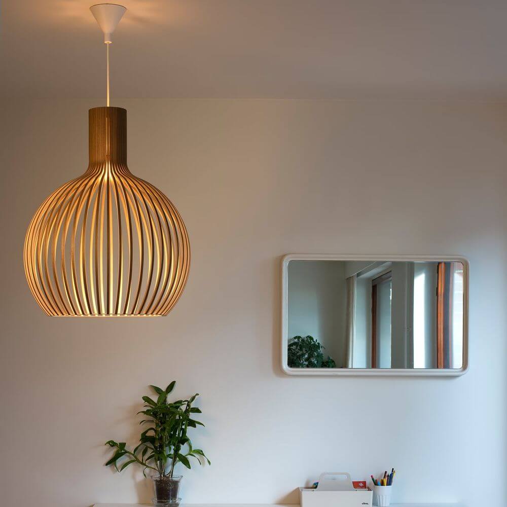 Pendelleuchte Octo Small 4241 aus Holz Ø 45cm in modernem Raum mit Pflanzen und Spiegel.