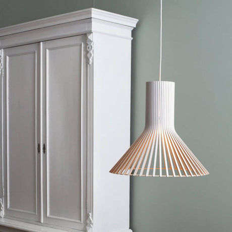 Puncto 4203 pendant light made of wood Ø 45cm hangs above a white cabinet in a modern interior.