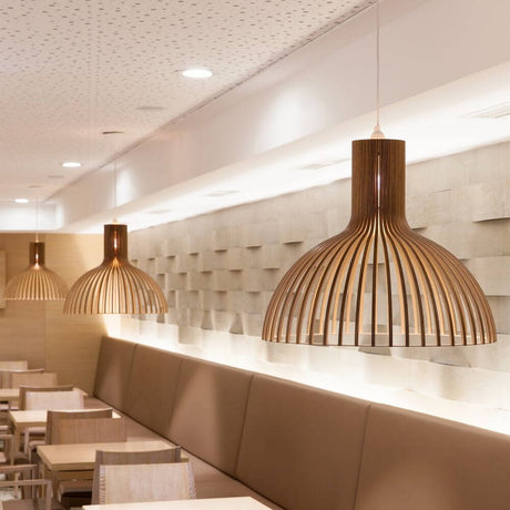 Victo 4250 pendant light made of wood Ø 56 cm in a modern restaurant setting with cozy lighting.