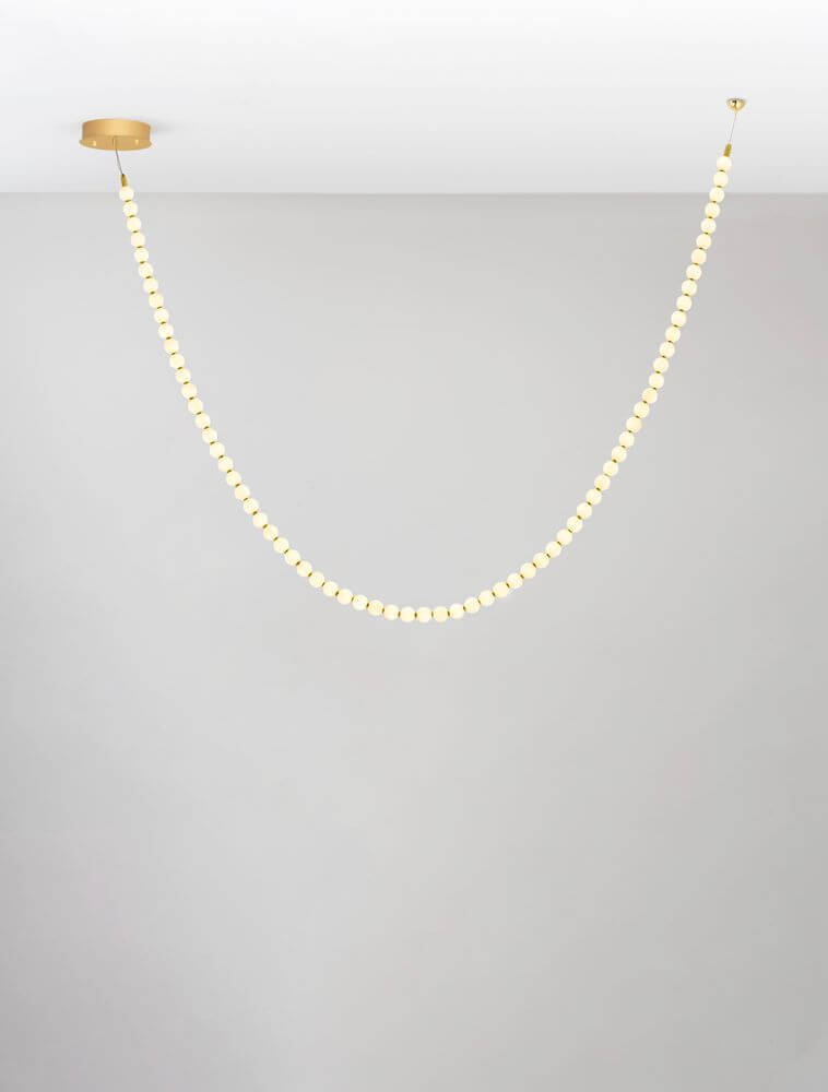 Perla LED Deckenleuchte 70-flammig 3000K Gold an einer Decke mit goldener Halterung.