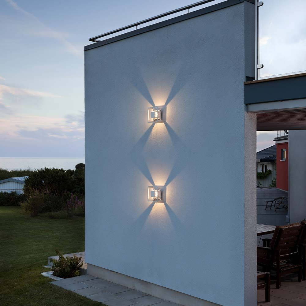 Pescara LED Außen-Wandleuchte Weiß, klares Glas an einer Wand im Freien mit sanfter Beleuchtung.