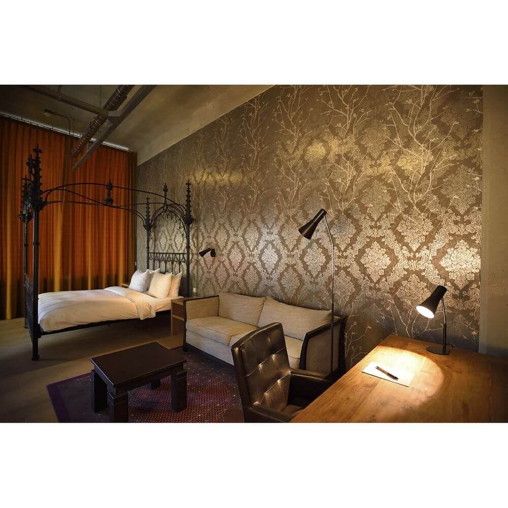 Elegantes Schlafzimmer mit Phelia Stehleuchte Schwarz und edlem Design, modernem Bett und gemütlicher Sitzecke.