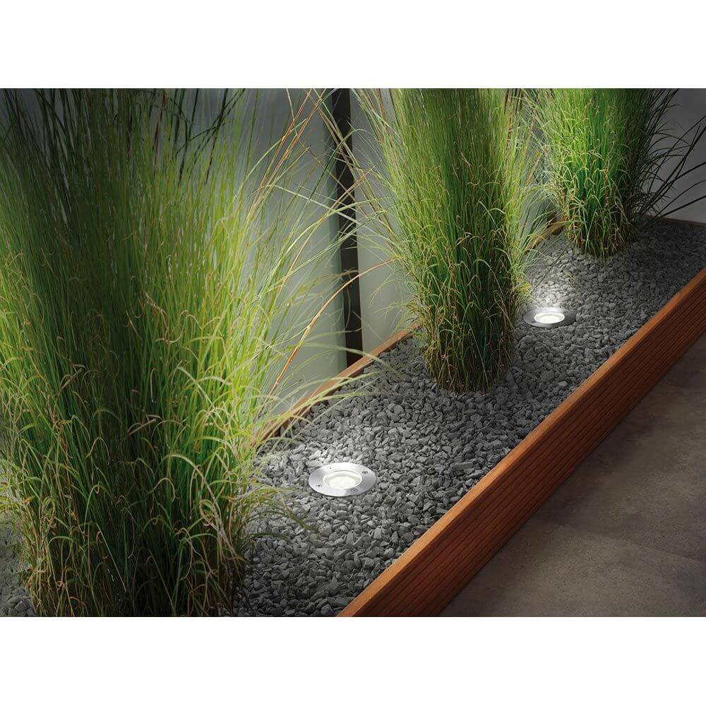 Plug & Shine LED Bodeneinbauleuchten in einem Garten mit Gräsern und Kies, ideal für smarte Gartenbeleuchtung.