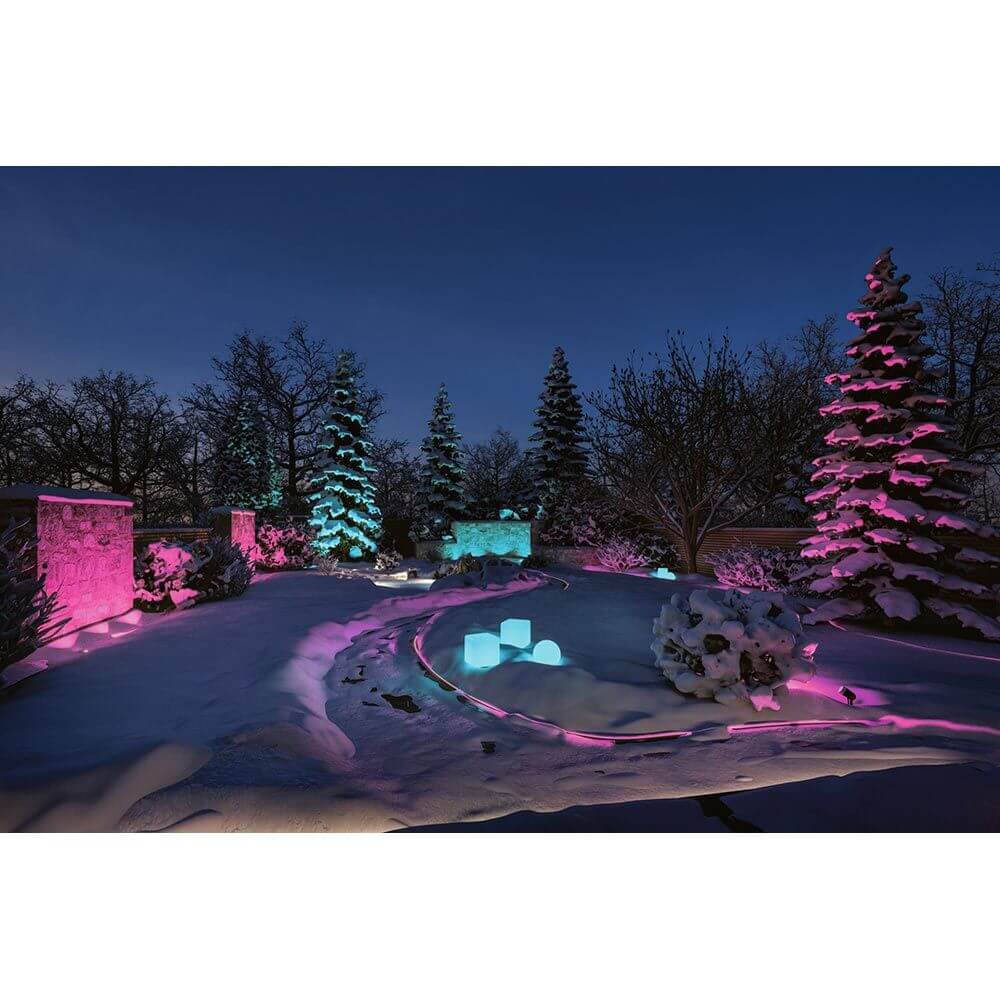 Beleuchteter Garten im Winter mit Plug & Shine LED Cube in Pink und Türkis, verschneite Bäume und Landschaft.