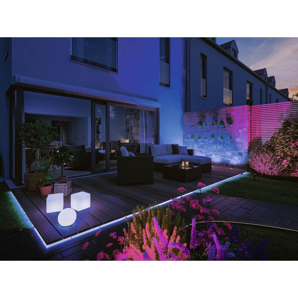 Beleuchtete Terrasse mit Plug & Shine LED Cube in unterschiedlichen Farben, umgeben von Pflanzen und modernem Design.