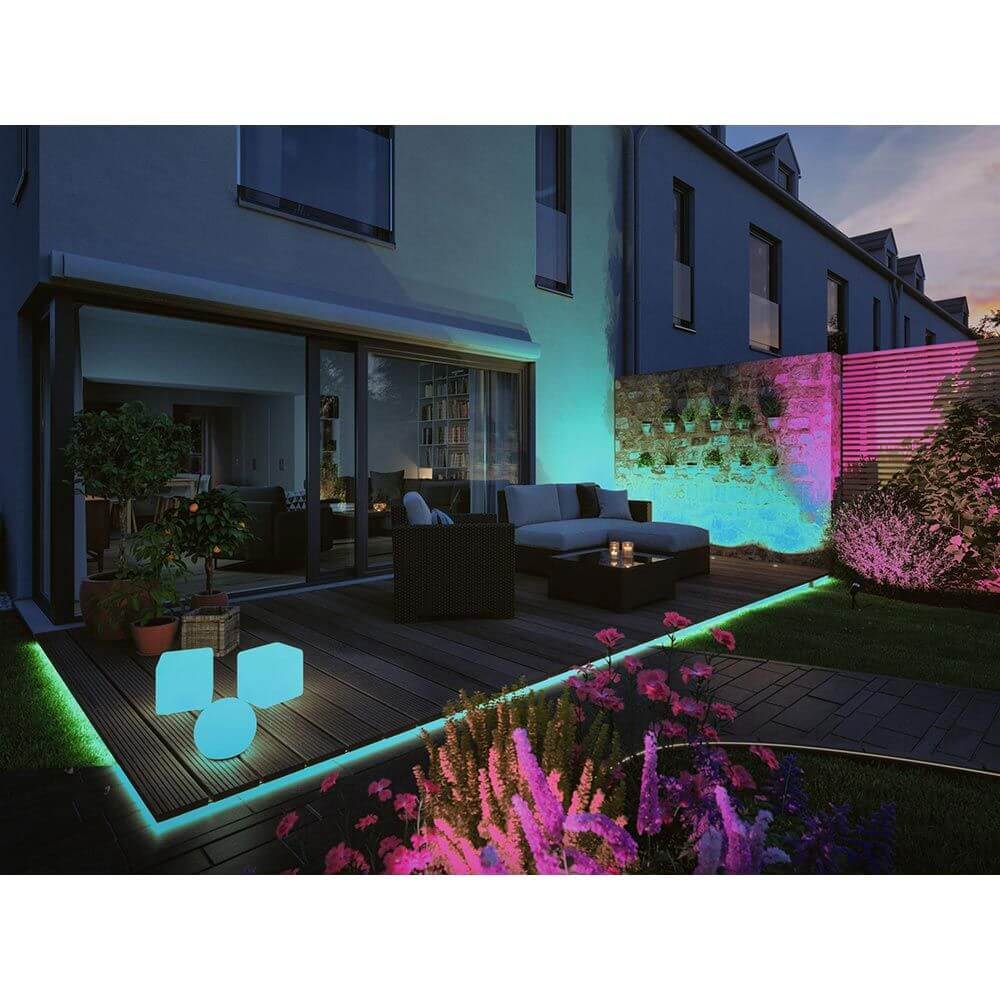 Beleuchteter Plug & Shine ZigBee Cube auf der Terrasse, umgeben von bunten Pflanzen und LED-Lichtakzenten.