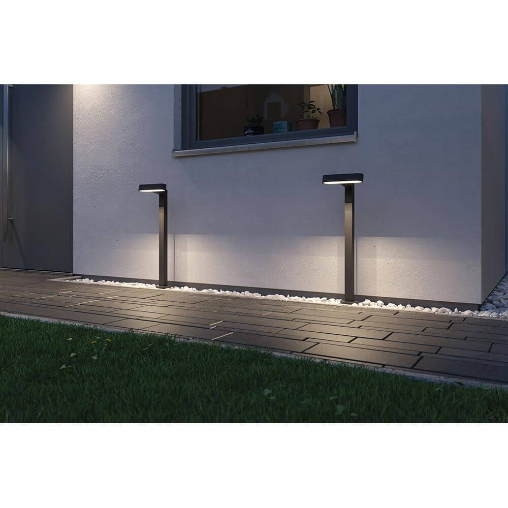 Plug & Shine LED Pollerleuchte Ito Horizontale Ausrichtung IP65 an der Wand mit Lichtstrahlen auf dem Boden.