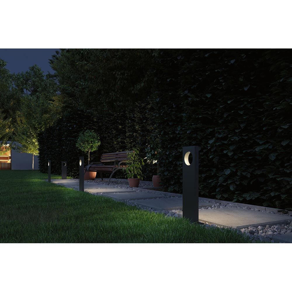 Plug & Shine LED Pollerleuchte Ivo IP65 Grau im Garten, beleuchtet einen Weg mit modernen Lichtakzenten.