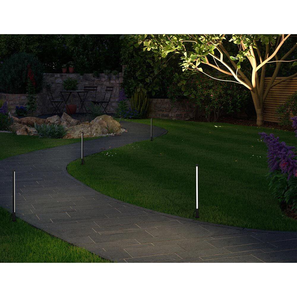 Plug & Shine LED Pollerleuchte in Anthrazit beleuchtet einen Gartenweg in warmem Licht.