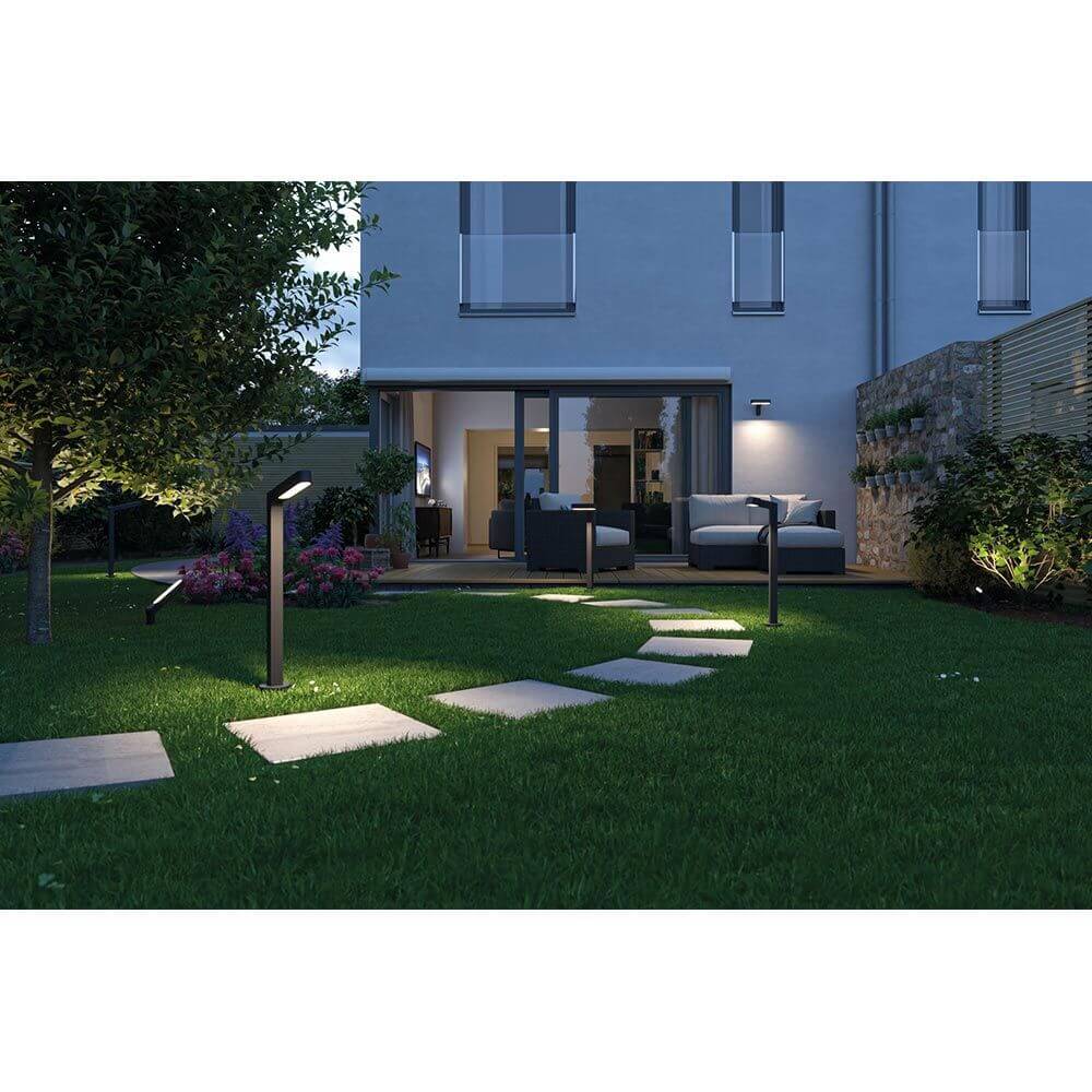 Moderne Plug & Shine LED Einzelstrahler Ito im Garten, Betonplatten und stilvolle Beleuchtung bei Nacht.