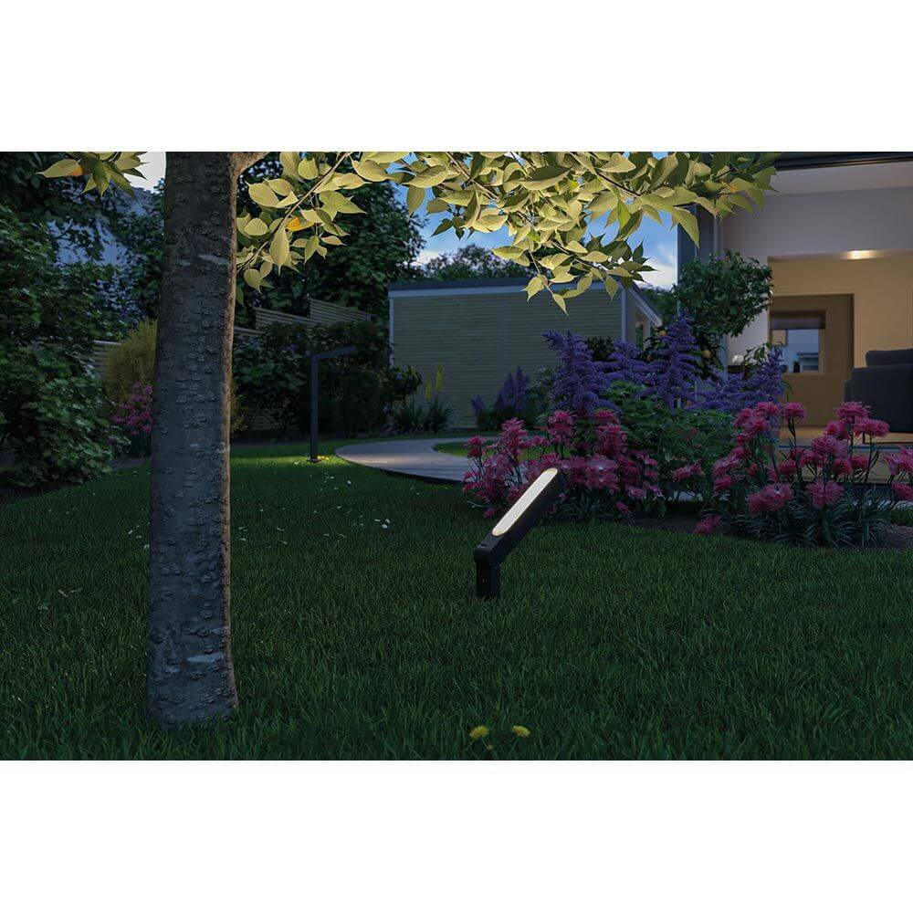 Plug & Shine LED Einzelstrahler Ito in Anthrazit im Garten, beleuchtet Blumen und Sträucher, hochwertige Außenbeleuchtung.